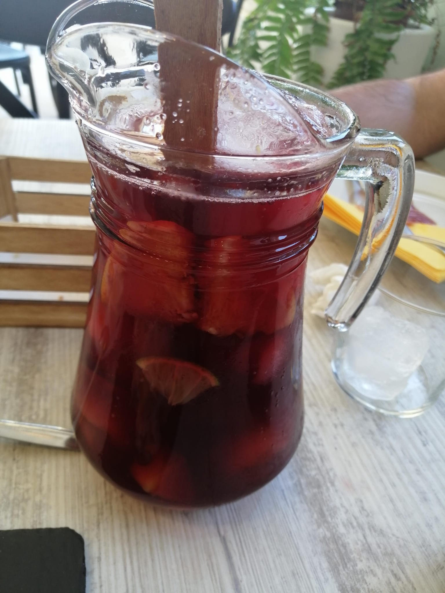 Pitcher of Spanish sangria with ice and fruit on patio table
